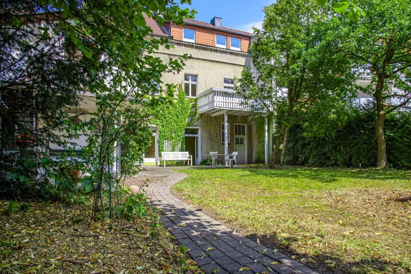 Rückansicht des Hauses mit Balkon, Terrasse und großem Garten