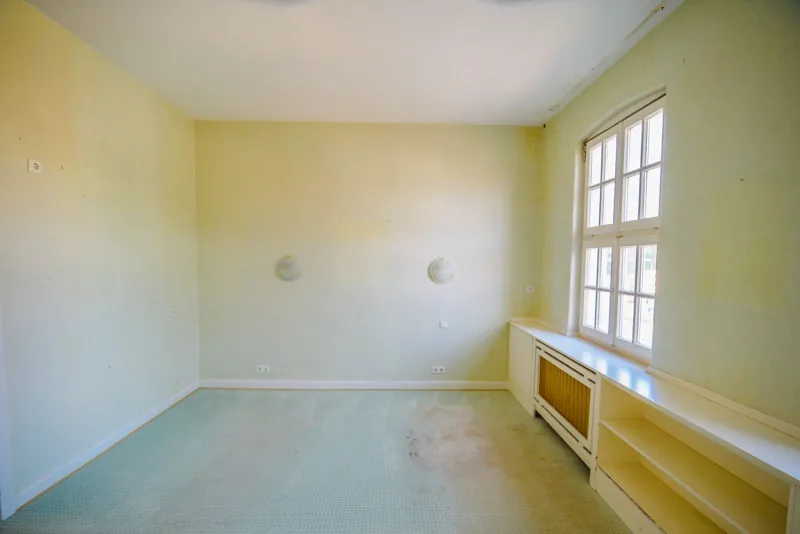 Schlafzimmer im 1. Obergeschoss mit großem Sprossenfenster