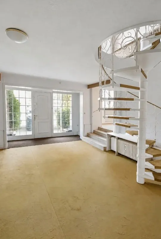 Heller Raum im Anbau mit weißer Wendeltreppe